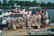 Large group of fishermen from Evil Eye Charters and Thumper Charters display the catch.