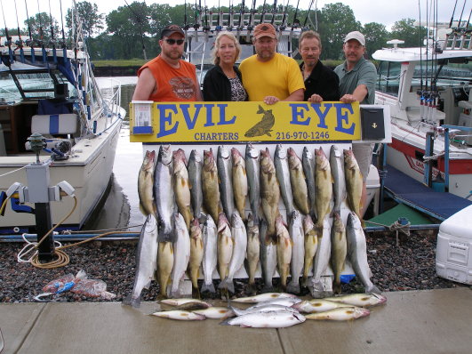 Group of five stands behind a catch of walleye and steelhead.