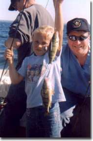 Happy kid holds up a double of perch while fishing on Lake Erie.