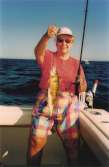 Older woman shows off two jumbo perch she reeled in.